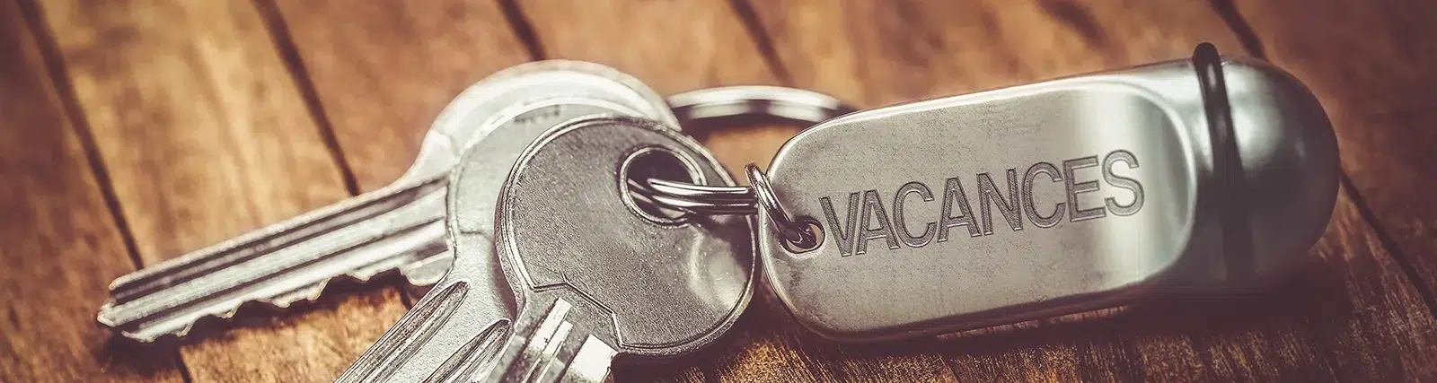 paire de clé d'hotel annotée le mot vacances sur le porte clé
